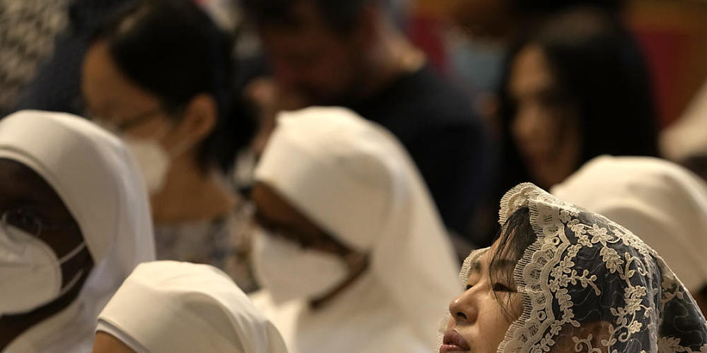 Eine Gläubige hört neben Nonnen im Petersdom die Pfingstmesse. Foto: Alessandra Tarantino/AP/dpa