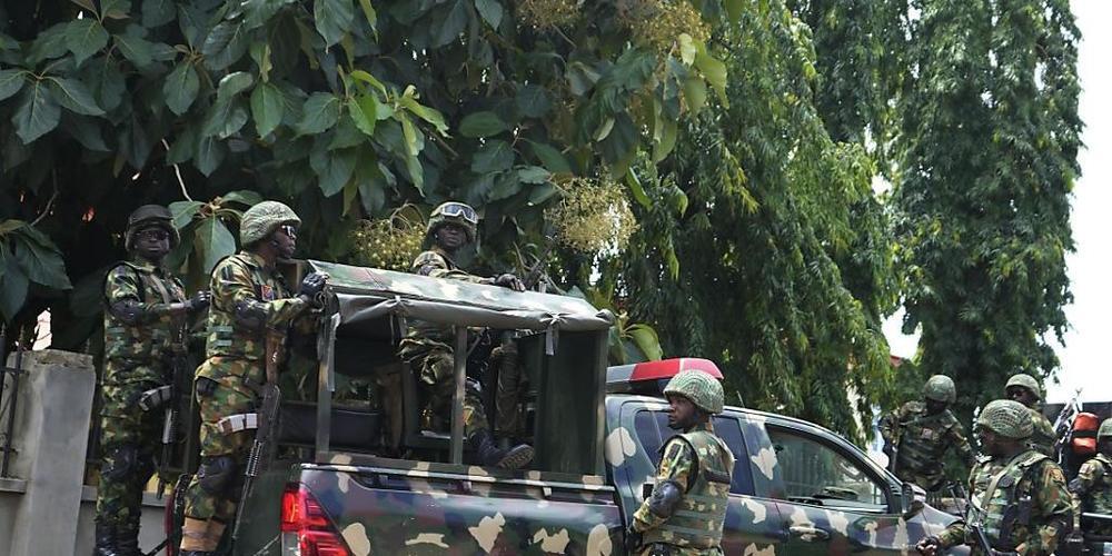 Nigerianische Soldaten sichern das Gelände vor der katholischen Kirche St. Francis. Nach einem brutalen Angriff auf eine katholische Kirche steigt die Opferzahl im westafrikanischen Nigeria auf bis zu 100. Foto: Sunday Alamba/AP/dpa