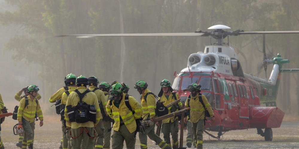 Feuerwehrleute, die die ganze Nacht über am Waldbrand in der Bergkette Sierra Bermeja gearbeitet haben, kommen mit dem Hubschrauber am Kommandoposten in Pujerra an. Mehr als 3000 Menschen sind in Spanien in der Nacht auf Donnerstag wegen des Waldb...
