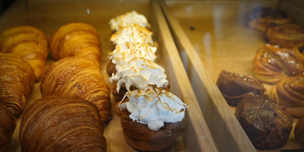 Ein Kiewer Stadtcafé bietet seinen Kunden einen nach dem britischen Premierminister Boris Johnson benannten Blätterteigkuchen (M) an. Damit wird Johnson für die britischen Militärspenden an die Ukraine gedankt. Foto: Efrem Lukatsky/AP/dpa