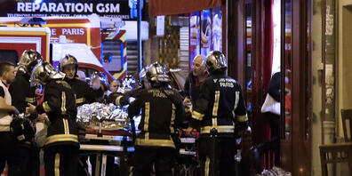 ARCHIV - Rettungskräfte versorgen die Opfer vor einem Café im 10. Bezirk. Frankreich stellt 20 Männer vor Gericht, die für die Terroranschläge des Islamischen Staates vom 13. November 2015 in Paris verantwortlich gemacht werden, bei denen 130 Mens...