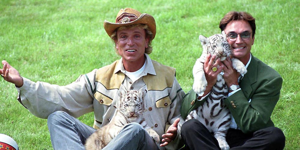 ARCHIV - Die deutschen Magier Siegfried (l) und Roy stellen sich im «Hollywood-Safari-Park» mit zwei weißen Tiger-Jungen den Fotografen vor. Hunderte Erinnerungsstücke aus dem Besitz des verstorbenen Zauber-Duos Siegfried und Roy sind in Kaliforni...
