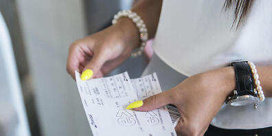 Eine Passagierin mit einem Flugticket in einer Checkin-Halle in Zürich-Kloten. (Archivbild)