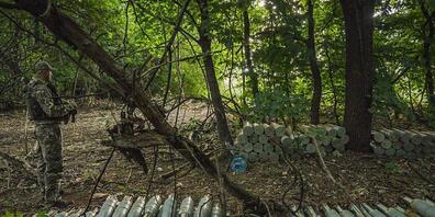 Ein ukrainischer Soldat steht neben in den Wäldern nahe der Provinz Saporischschja versteckten Haubitzen-Munition, die für den Beschuss der russischen Stellungen vorbereitet wurden. Foto: Celestino Arce Lavin/ZUMA Press Wire/dpa