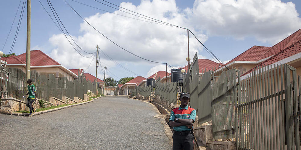 ARCHIV - Ein Wachmann steht in der Hauptstadt auf der Straße vor den Hallmark Residences, einem der Standorte, an denen einige der Asylsuchenden untergebracht werden sollen, die von Großbritannien nach Ruanda geschickt werden sollen. Foto: Uncredi...