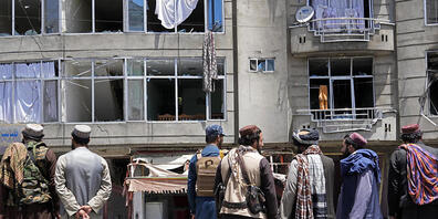 Taliban-Kämpfer versammeln sich am Ort einer Explosion vor einem Sikh-Tempel. Foto: Ebrahim Noroozi/AP/dpa