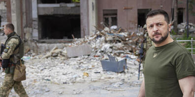 HANDOUT - Wolodymyr Selenskyj (r), Präsident der Ukraine, besichtigt beschädigte Gebäude während er die vom Krieg betroffene Region Mykolajiw besucht. Foto: -/Ukrainian Presidential Press Office/AP/dpa - ACHTUNG: Nur zur redaktionellen Verwendung ...