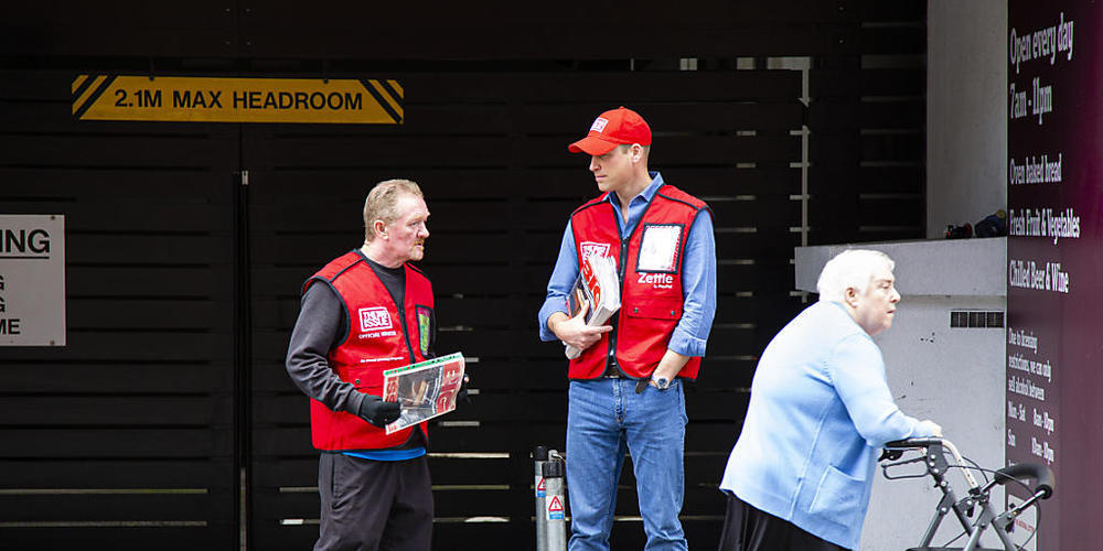 HANDOUT - Prinz William (M), Herzog von Cambridge hilft dem Big Issue-Verkäufer Dave Martin (l) beim Verkauf des Magazins. Die Straßenzeitung hat es sich zum Ziel gesetzt obdachlosen, langzeitarbeitslosen und ausgegrenzten Menschen die Möglichkeit...