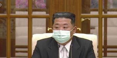SCREENSHOT - Nordkoreas Machthaber Kim Jong-un trägt während eines Treffens zum ersten Corona-Fall im Land einen Mund-Nasen-Schutz. Foto: Uncredited/KRT/AP/dpa