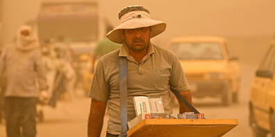 Sand- und Staubstürme haben Bagdad in  orangefarbenen Dunst gehüllt. Foto: Hadi Mizban/AP/dpa