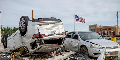 Zwei stark beschädigte Fahrzeuge stehen nach einem Tornado auf dem Parkplatz von Hobby Lobby nahe des Michigan State Highway 32. Foto: Jake May/MLive.com/The Flint Journal via AP/dpa - ACHTUNG: Nur zur redaktionellen Verwendung und nur mit vollstä...