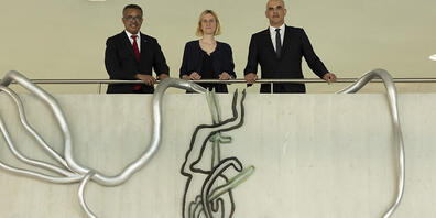 WHO-Generalsekretär Tedros Adhanom Ghebreyesus (links), die Schweizer Künstlerin Simone Holliger (Mitte) und Bundesrat Alain Berset (rechts) posieren über Teilen von Holligers Kunstwerk "Früchte tragen". Das Werk ist ein Geschenk der Schweiz an di...