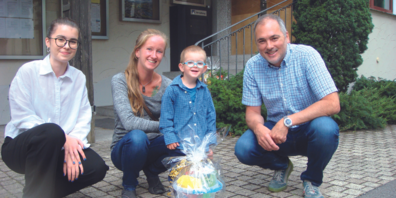 Mason Wellinger, zusammen mit seiner Mama Maria Wellinger, freute sich über das kleine Präsent, welches ihm von Gemeindepräsident Christian Sepin (rechts) und Sara Skara (links), Sachbearbeiterin Einwohnerdienste überreicht wurde.