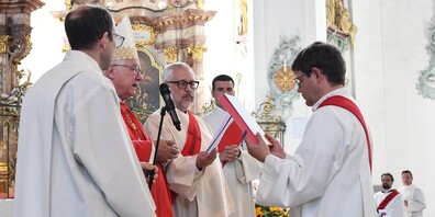Bischof Markus Büchel übergibt Martin Rusch das Evangeliar.   