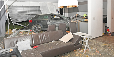 Beim Unfall wurde der Fahrzeuglenker und eine sich im Wohnzimmer befindende Person verletzt.