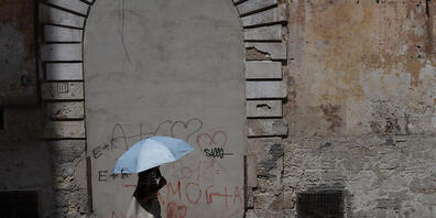 Eine Frau schützt sich im italienischen Taranto mit einem Schirm vor der Hitze. Am Wochenende soll es nun sogar noch heißer werden. Foto: Matias Basualdo/ZUMA Press Wire/dpa