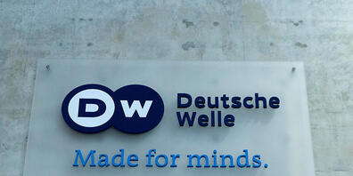 ARCHIV - Ein Schild mit dem Schriftzug «DW Deutsche Welle Made for minds.» Foto: Carsten Koall/dpa