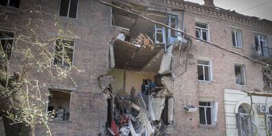 Menschen bergen einige ihrer Habseligkeiten aus einem Gebäude in Bachmut, das bei einem russischen Raketenangriff im Stadtzentrum beschädigt wurde. Foto: Efrem Lukatsky/AP/dpa