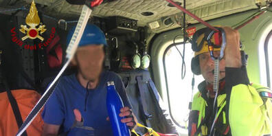 HANDOUT - Ein Wanderer sitzt nach seiner Rettung an Bord eines Helikopters. Ein italienischer Wanderer hat nach einem Absturz sieben Tage ohne Essen und fast ohne Wasser überlebt. Der 31-Jährige wurde am Samstag von den Rettungskräften in einer Fe...