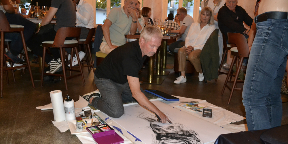 Kunst im Zentrum: Künstler Jürg Ruess malt Aktbilder umgeben von Gästen, die auch musikalische Leckerbissen serviert bekommen.