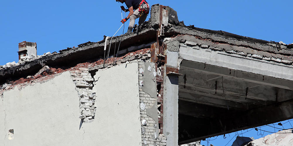 Arbeiter demontieren ein Gebäude, das durch Raketenbeschuss der russischen Truppen beschädigt wurde. Foto: -/Ukrinform/dpa