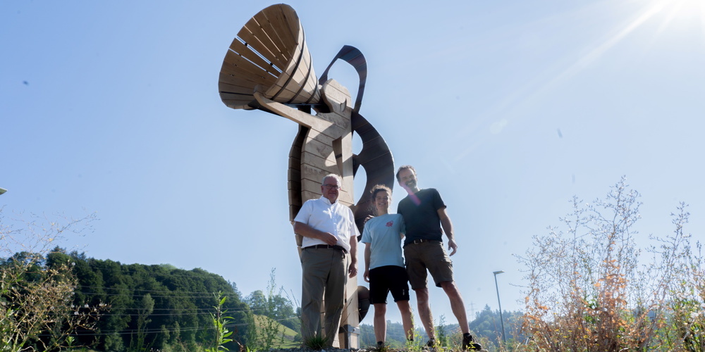 Künstler Dominik Hollenstein und Tochter Christina überbringen Jon Fadri Huder, Gemeindepräsident von Ebnat-Kappel (links), den Klangbotschafter an seinem neuen Standort im Kreisel Stegrüti.