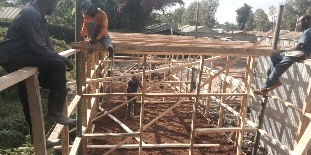 Holz als Hauptbaumittel: Arbeiter bei Vorbereitungsarbeiten für das neue Schulgebäude. 