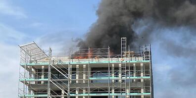 Schwarzer Rauch steigt vom brennenden Dachstock des im Bau befindlichen Mehrfamilienhauses in den Himmel.