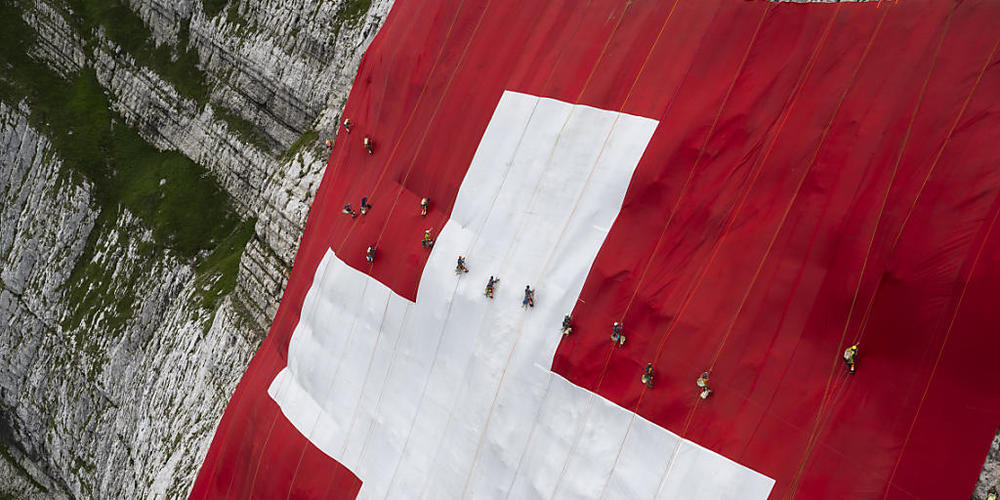 Die 80 mal 80 Meter grosse Schweizerfahne hängt an einer Felswand unterhalb des Säntis in der Ostschweiz.