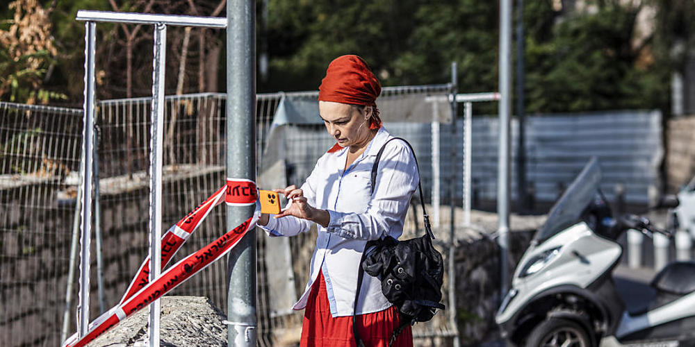 Eine israelische Frau fotografiert  den Tatort eines Anschlags durch Schüsse in der Nähe der Jerusalemer Klagemauer. Nach Angaben der israelischen Polizei und von Sanitätern eröffnete ein bewaffneter Mann das Feuer auf einen Bus. Foto: Ilia Yefimo...