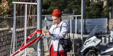 Eine israelische Frau fotografiert  den Tatort eines Anschlags durch Schüsse in der Nähe der Jerusalemer Klagemauer. Nach Angaben der israelischen Polizei und von Sanitätern eröffnete ein bewaffneter Mann das Feuer auf einen Bus. Foto: Ilia Yefimo...