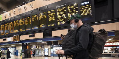Ein Mann checkt am Londoner Bahnhof King's Cross St. Pancras seine Verbindung. Zugführer in Grossbritannien kämpfen mit einem Streik für bessere Arbeitsbedingungen. (Archivbild)