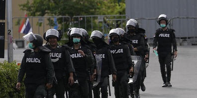 ARCHIV - Thailändische Polizeikräfte patrouillieren vor dem Regierungsgebäude in Bangkok (Symbolbild). Foto: Sakchai Lalit/AP/dpa