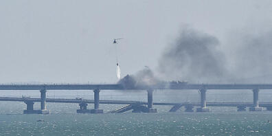 dpatopbilder - Ein Hubschrauber wirft Wasser ab, um das Feuer auf der Krim-Brücke zu stoppen, die das russische Festland und die Halbinsel Krim über die Straße von Kertsch verbindet. Foto: Uncredited/AP/dpa