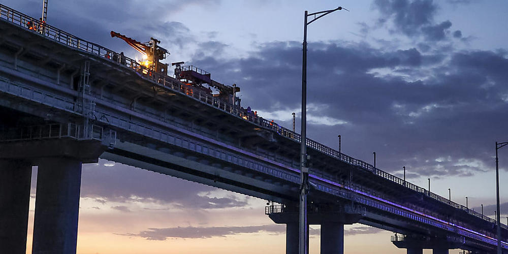 Arbeiter reparieren den Eisenbahnteil der Krim-Brücke, die das russische Festland und die Halbinsel Krim über die Meerenge von Kertsch verbindet. Foto: Uncredited/AP/dpa
