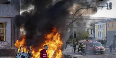 Ein Sanitäter geht nach einem russischen Angriff auf Kiew an einem brennenden Auto vorbei. Foto: Roman Hrytsyna/AP/dpa