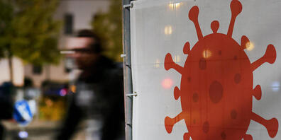 Ein grosses Virus-Symbol weist auf eine Corona-Teststation hin.