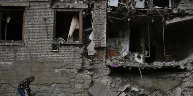 Ein Anwohner steht vor einem beschädigten Haus, das in der Nacht beschossen wurde. Foto: Andriy Andriyenko/AP/dpa