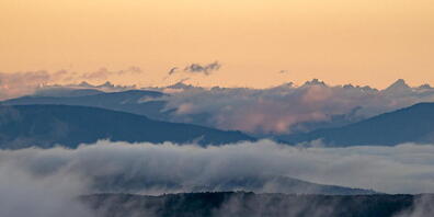 Die schneebedeckten Gipfel der slowakischen Hohen Tatra sind im Hintergrund einer Nebeldecke zu sehen, die die Landschaft bedeckt, aufgenommen in der Nähe von Salgotarjan, Nordungarn. Foto: Peter Komka/MTI via AP/dpa