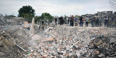 Helfer beseitigen Trümmer an einem Krater nach einem Luftangriff. Russlands Armee hat nach ukrainischen Angaben mit mehreren Raketen Wohnhäuser bombardiert und zahlreiche Zivilisten getötet. Foto: ---/ukrin/dpa