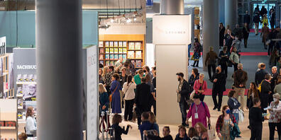 Besucher gehen während des ersten Tags der Frankfurter Buchmesse durch eine Halle. Foto: Sebastian Christoph Gollnow/dpa - Nutzung nur nach schriftlicher Vereinbarung mit der dpa