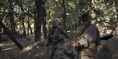 Ukrainische Soldaten überprüfen die von russischen Soldaten ausgehobenen Schützengräben. Foto: Leo Correa/AP/dpa