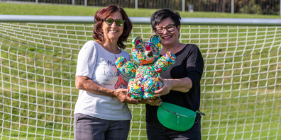 Sabeth Holland (rechts) und Marlène Tinner von der alea iacta AG mit dem «Lovable»-Bärchen «Footie». 