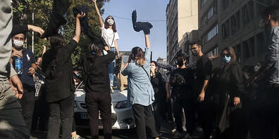 Eine Frau steht während einer Demonstration anch dem Tod der 22-jährigen Mahsa Amini auf einem Auto und gestikuliert. Foto: Uncredited/AP/dpa