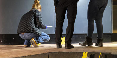Polizisten sichern Spuren am Tatort im Außenbereich eines Fast-Food-Restaurants. Foto: Christoph Reichwein/dpa