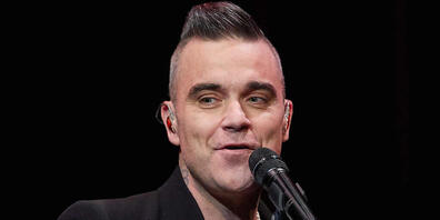 Der Sänger Robbie Williams auf der Bühne bei einem Konzert in Hamburg. (Archivbild)