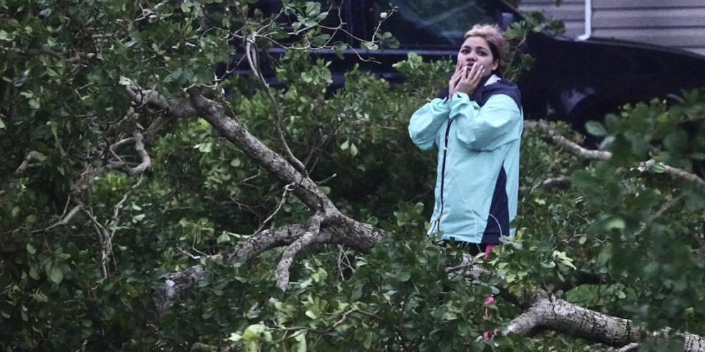 Eine Frau begutachtet die Schäden rund um ihr Mobilheim in Davie, Florida. Hurrikan «Ian» hat auf seinem Weg in Richtung Florida weiter an Kraft zugenommen. Foto: Joe Cavaretta/South Florida Sun-Sentinel/dpa
