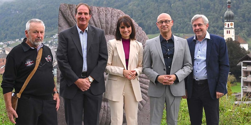 Stein-Schnecke aus Verrucano: Josef Riederer, Désirée Guntli, Marcel Ryser und Guido Fischer (Zweiter bis Fünfter von links) freuen sich mit Künstler Konradin Imthurn (ganz links) über die Enthüllung der Skulptur. (Bild Hans Bärtsch)