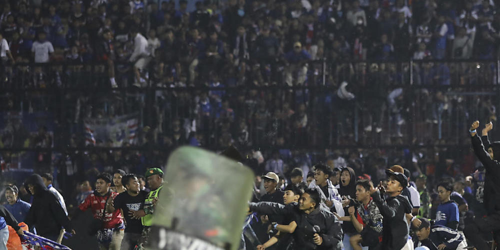 dpatopbilder - Fußballfans stürmen das Spielfeld während Zusammenstößen zwischen Fans im Kanjuruhan-Stadion nach dem Erstliga-Spiel zwischen Arema FC und Persebaya FC in Malang. Foto: Yudha Prabowo/AP/dpa