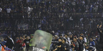 dpatopbilder - Fußballfans stürmen das Spielfeld während Zusammenstößen zwischen Fans im Kanjuruhan-Stadion nach dem Erstliga-Spiel zwischen Arema FC und Persebaya FC in Malang. Foto: Yudha Prabowo/AP/dpa